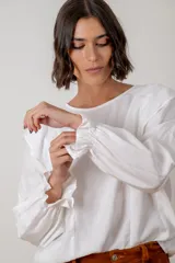 Blusa de algodón color bordó, con diseño de volados en los hombros, mangas largas con puños elásticos y corte holgado.