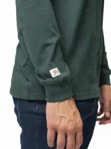 Remera de manga larga con cuello redondo, confeccionada en algodón, de corte clásico y diseño minimalista con detalle de etiqueta pequeña en el ruedo.
