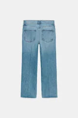 Jeans cropped flare de tiro medio color celeste, confeccionados en denim con efecto lavado. Presentan diseño de cinco bolsillos, trabillas para cinto, raya planchada al frente y bajo desflecado con terminación evasé. Cuenta con cierre frontal de cremallera y botón metálico.