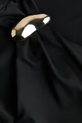 Top entallado sin mangas de punto elástico suave, con escote asimétrico y detalle metálico dorado en un hombro. Cuenta con frunces laterales que generan un efecto drapeado.