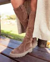 Bota alta de gamuza color arena, con caña alta y suela track.