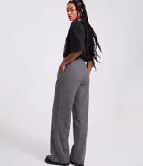 Pantalón wide leg de sastrería color gris con estampado de raya de tiza, tiro alto con cintura fija, pliegues delanteros y cierre frontal con botón y cremallera.
