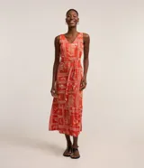 Vestido midi sin mangas confeccionado en viscosa estampada con motivos geométricos y florales en tonos naranja y blanco. Presenta escote en V, corte a la cintura con lazo y falda con volantes.