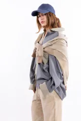 Buzo de algodón y cáñamo color beige con efecto lavado, escote en V y diseño con cortes estructurales en cuerpo y mangas. Presenta puños y cintura tejidos en tono contrastante.