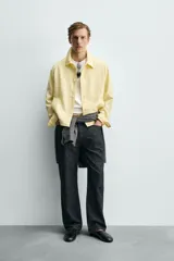 Sobrecamisa relaxed fit de color amarillo claro, confeccionada en tejido con mezcla de lyocell. Presenta cuello solapa, mangas largas raglán con puños abotonados, bolsillos de vivo en la cadera y cierre frontal con botonadura.