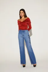 Blusa negra con escote off-shoulder y mangas largas ajustadas.