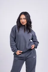 Canguro blanco con capucha, bolsillos laterales y logo pequeño bordado en negro en el pecho.