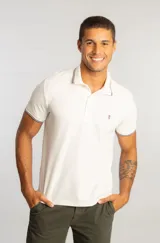 Camisa polo de manga corta en color off white, confeccionada en tejido piquet. Presenta cuello y puños con detalles de frisos tricolor y cierre frontal con botones. Incluye un pequeño logo bordado en el pecho.