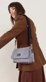 Bandolera capitoneada color bordó, con bolsillo interno, correa de galón ajustable y tapa con broche.