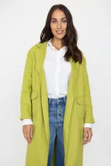 Chaqueta larga de corte relajado color verde pistacho, con solapas clásicas y bolsillos frontales con solapa. Presenta un diseño abierto sin botones, ideal para un estilo casual y versátil.