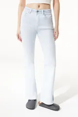 Jean celeste de tiro medio/alto, silueta levemente acampanada desde la rodilla, con tajo en el bajo y bordado floral en la pretina.