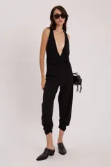 Pantalón negro de corte holgado con elástico en los tobillos.