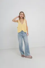 Chaleco celeste de punto con escote en V y cierre frontal con botones. Tejido calado y corte holgado.