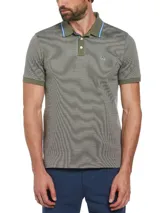 Polo de piqué color verde oliva con diseño jacquard y logo de pingüino bordado en el pecho. Cuello y mangas con ribete liso.