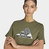 Remera Adidas de corte clásico y cuello redondo, confeccionada en tejido de punto jersey de algodón. Presenta un estampado frontal con el logo de la marca en diseño de camuflaje multicolor.