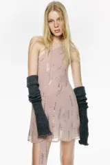 Vestido corto de escote asimétrico con foulard integrado, confeccionado en tejido con aplicación de lentejuelas brillantes.