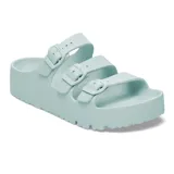 Sandalias de plataforma tipo slide, color verde agua, con tres correas ajustables con hebillas del mismo tono y suela dentada.