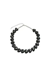 Collar de cadena metálica plateada con dijes de corazones negros de material plástico brillante intercalados.