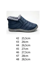 Bota corta de nailon matelaseado color azul marino, con interior y reborde forrados en piel sintética gris. Posee elástico en los laterales para un calce cómodo y suela de goma gris.