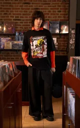 Remera de manga corta con cuello redondo y corte oversize, confeccionada en algodón premium. Presenta un estampado frontal con diseño gráfico inspirado en la banda The Prodigy, con elementos visuales que incluyen rostros, tipografía y motivos abstractos.