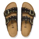 Sandalia Birkenstock modelo Arizona de dos correas, confeccionada en gamuza negra con tachas doradas decorativas y hebillas metálicas ajustables. Cuenta con plantilla ergonómica de corcho y suela de goma antideslizante.