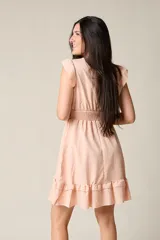 Vestido corto blanco con cuello en V, mangas cortas con volados, cintura elastizada y falda con volados.