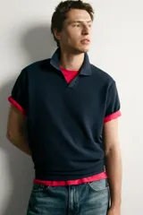 Polo de punto tejido en hilatura de algodón color azul marino, de corte regular fit, con cuello solapa y abertura frontal sin botones, manga corta y terminaciones en rib.