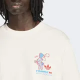 Remera de algodón color blanco con cuello redondo y mangas cortas. Presenta un pequeño estampado en el pecho que incluye la mascota Footix y el logo del Trifolio de Adidas.