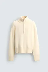 Jersey de punto color blanco con efecto pelo, cuello subido y cierre frontal de cremallera, de corte regular fit y manga larga con acabados en rib.