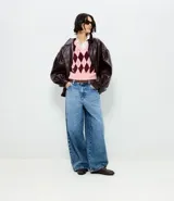 Pantalón de jean con corte barrel, de cintura media y perneras amplias con bajo afunilado. Cuenta con bolsillos funcionales, cierre tradicional y trabillas para cinturón. Incluye un pañuelo estampado desmontable en la cintura.