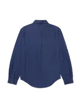 Camisa de manga larga Caterpillar de color azul, confeccionada en mezcla de tencel y algodón. Cuenta con cuello clásico, cierre frontal de botones, dos bolsillos en el pecho con solapa y botones, y diseño con mangas convertibles tipo roll-tab.