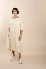 Vestido midi acampanado de lana fina sin teñir, con cuello bote, mangas tres cuartos con tajo y bolsillos laterales. Diseño forrado con vuelo y movimiento.