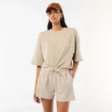 Short de felpa beige de corte holgado, con cintura elástica ajustable mediante cordón y bolsillos laterales.
