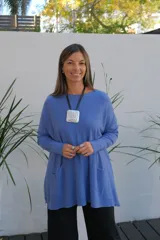 Sweater de punto color celeste, de corte holgado y largo, con mangas largas, cuello redondo y dos bolsillos frontales tipo parche.