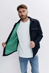Campera tipo sobrecamisa de lana en color azul marino, con cuello clásico, cierre frontal con botones y bolsillos frontales con solapa. Presenta un forro interno en color verde.
