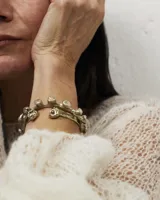 Pulsera esclava abierta de diseño artesanal con acabado orgánico y texturizado, realizada en bronce.
