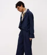 Pantalón de poliamida color azul marino, con diseño barrel de piernas anchas, cintura estructurada con pasacintos y pinzas frontales. Cuenta con botamanga levemente ajustada.