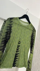 Top de microtul verde con estampado abstracto en tonos verdes y negros, de mangas largas y cuello redondo.