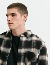 Sobrecamisa de manga larga con diseño a cuadros, cuello camisero y bolsillo frontal. Confeccionada en tejido de poliéster y algodón, sin forro.