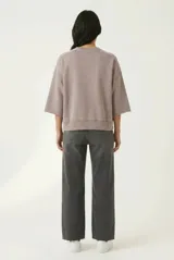 Sweatshirt de algodón color marrón con cuello redondo, mangas 3/4 y un bolsillo aplicado en el frente con terminaciones deshilachadas.