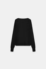 Jersey de punto fino negro con escote en V profundo y manga larga con puños ajustados.