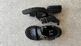 Sandalias de cuero marrón oscuro con efecto desgastado, tiras cruzadas en el empeine, hebilla metálica lateral y suela track negra con plataforma.