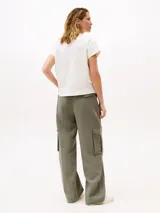 Remera de algodón con cuello redondo, mangas tipo kimono y detalle de botones dorados en el hombro.