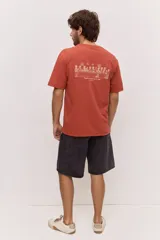 Remera blanca de algodón, de corte holgado y mangas cortas, con pequeño estampado azul en el pecho.