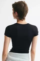 Remera entallada de microfibra en color negro, con cuello redondo fino y mangas cortas.