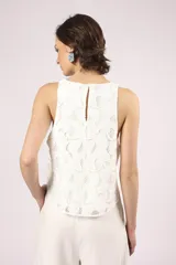 Blusa blanca de broderie con cuello redondo y sin mangas.