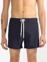 Short de baño para hombre color azul marino, con calce relajado y una tira lateral blanca estilo tuxedo. Presenta cintura elástica con cordón regulable, bolsillos laterales y trasero con cierre.