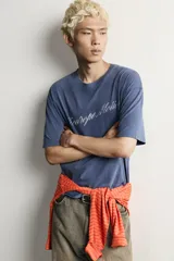 Remera boxy fit azul con efecto lavado, cuello redondo y manga corta, con estampa en el pecho.