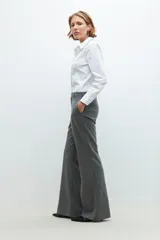 Pantalón de vestir gris con finas rayas verticales, corte sastrero y pierna ancha.