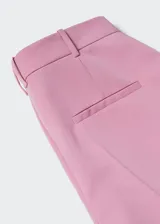 Pantalón de vestir de corte recto y tiro medio, confeccionado en tejido fluido. Cuenta con trabillas en la cintura, dos bolsillos laterales y dos bolsillos de ribete en la parte posterior.